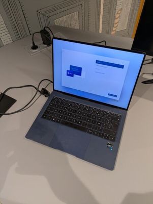 un ordinateur portable posé sur une table, avec une souris et un clavier