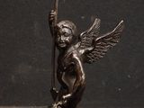 bronze statue of an angel with a spear and arrow on a black background