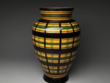 a vase that is sitting on a table with a black base