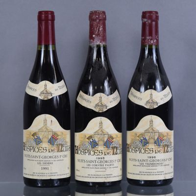 three bottles of red wine sitting on top of a glass table