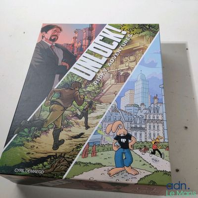 La boîte du jeu de société « Uncle II » est posée sur une table.