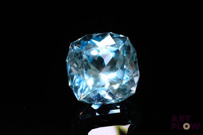 an image of a blue topaz diamond on a black surface