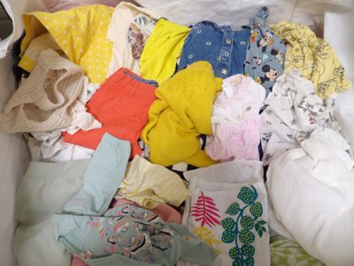 a white box filled with lots of clothes and a cell phone