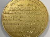 a close up of a gold coin on a white surface