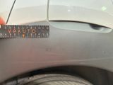 someone is measuring the width of a car ' s tire with a ruler