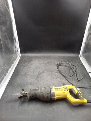 une perceuse à fil jaune et noire posée sur une surface noire
