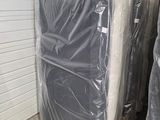 many mattresses wrapped up in plastic in a warehouse