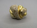 un gros plan d'une bague en or et diamants posée sur une table