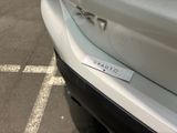 a sticker on the bumper of a car that is parked in a parking lot