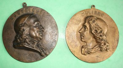 two bronze medallions of a man and a woman