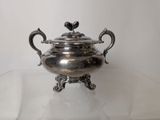 a silver teapot sitting on a glass table