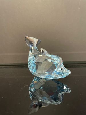 un gros plan d'un oiseau en cristal posé sur une table en verre