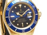 a close up of a watch with a blue dial on a gold bracelet