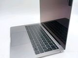 a silver laptop with a black keyboard on a white surface