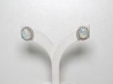 une paire de boucles d'oreilles en oplite et diamants, présentées sur un socle blanc