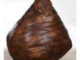 un pouf en cuir marron posé sur un sol blanc