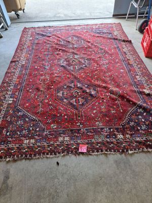 rug on the floor in a room with chairs and a red chair