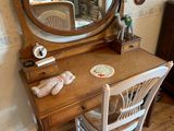 a small desk with a mirror and a chair in the room