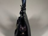 the small black purse is sitting on a white surface