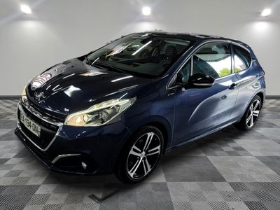 une voiture bleue garée dans un garage au sol en damier