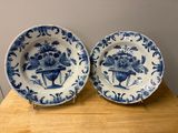deux assiettes bleues et blanches ornées de fleurs, posées sur une table en bois