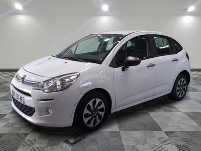 the small white car is parked on a checkered tile floor