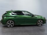 the green car is parked on the concrete floor in the room