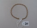 bracelet orné de perles dorées et d'une étiquette sur un fond blanc