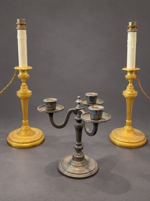 trois bougies sont posées sur une table, entourées d'une chaîne
