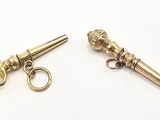deux paires de ciseaux dorés et une paire de ciseaux posés sur une surface blanche