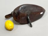 a wooden duck with a knife and a lemon on the table