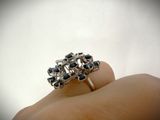 a person holding a silver ring with black stones on it