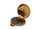 a close up of a gold pocket watch on a white surface