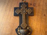 une croix accrochée au mur, posée sur une table en bois