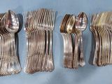 six forks and spoons are lined up on a blue surface