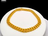 a gold necklace on a white plate on a table