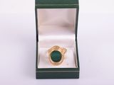 an image of a gold ring with a green stone in a box