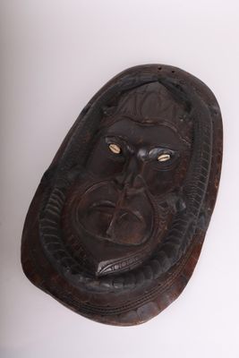 un vieux masque en bois accroché au mur d'une pièce