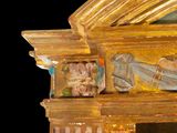a mirror that has a gold frame with a painting on it