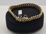 un bracelet en chaîne d'or dans un coffret en velours noir