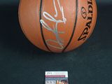 an autographed basketball with a ticket and a card