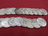 a close up of a bunch of silver coins on a red surface