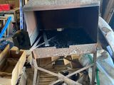 un grand four métallique posé sur une palette dans un garage