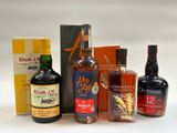 bottles of various types of alcohol are lined up on a white surface