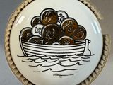 a plate with a boat full of coins on it