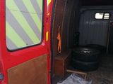 a red van with its door open and a tire in the back