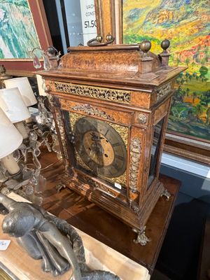 une horloge posée sur une table devant un tableau