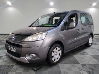 La camionnette grise est garée dans une grande pièce au sol carrelé en damier.