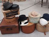 un tas de chapeaux et de valises posés par terre
