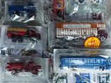 beaucoup de petits trains en plastique dans des sacs en plastique, par terre